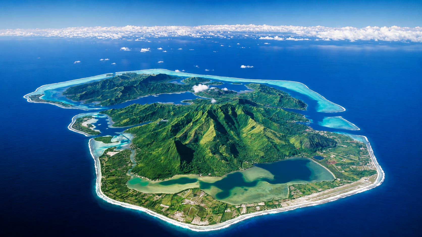 Aerial view of a lush tropical island surrounded by turquoise lagoon — explore exclusive tour packages with Travokart